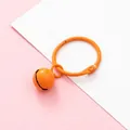 Orange resin bell keychain variant with metallic ring on pink and white background - Orange