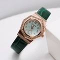 Macro view of rose gold octagonal watch case with diamonds and green leather strap - Green