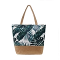 Canvas tote bag with tropical leaf print and brown jute base shown in studio - Style 5/Green Leaves