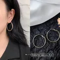 Detailed view of 4cm gold hoop earrings with model display and high-shine metallic finish - 4cm / Minimalist Hoop / Gold