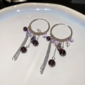 Detailed macro view of purple beaded tassel hoop earrings with crystal on white ceramic plate - Silver Ear Buckle - Purple Style