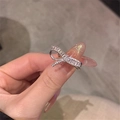 Detailed close-up of a silver bow ring with sparkling crystals worn on a finger - Bowknot Irregular
