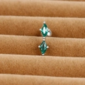 Detail of silver cartilage stud with two marquise-cut green zircons on a brown tray - Double Marquise Design (E1357-5)