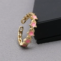 Close-up of golden braided chain ring with pink enamel stars and adjustable open design - Adjustable Open / Pink