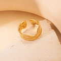 Detalle de anillo dorado con textura martillada sobre piedra con una estética minimalista - Estilo de Onda Irregular (40247) / Dorado