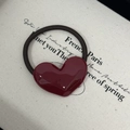 Detail of burgundy heart-shaped acetate hair tie with gold 'France Handmade' lettering - Burgundy