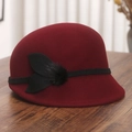 Détail d'un chapeau cloche en laine bordeaux avec ruban noir sur une table en bois - M (56-58cm) / Rouge Vin (Avec Boule de Fourrure de Vison et Décoration de Nœud)