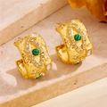Makro-Detail von 18K vergoldeten C-Ohrringen mit Hammerschlag-Textur und grünem Edelstein - Böser Blick C-Form Ohrstecker Gold