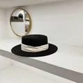 Detalle de sombrero canotier de paja negra con cinta plisada beige y hebilla dorada - M (56-58cm) / Negro
