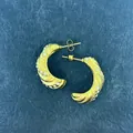 Dettaglio di orecchini a cerchio in oro 18k intrecciato con diamanti incastonati - Croissant Con Pietre