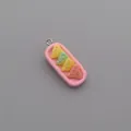 Macro view of a resin pink tray charm featuring colorful mini cheese blocks and metal loop - Colorful Cake