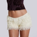 Détail d'un short en dentelle blanc cassé avec volants en mesh et nœud décoratif chic - Blanc Cassé