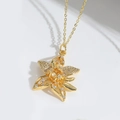 Macro shot of gold flower pendant necklace with white zircons on minimalist chain - Zirconia Chrysanthemum