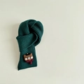 Detail view of dark green knitted scarf with cute cartoon bear patch and vertical stripes - Dark Green