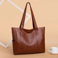 Brown soft texture leather tote bag with large capacity in a professional studio setting - Brown