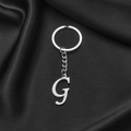 Polished silver stainless steel alphabet G keychain on black satin background - Letter G