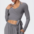 Detail of grey wrap-style yoga top and pants showing waist tie-up design and soft fabric - S / Tops / Smoke