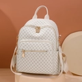 White monogram backpack with gold hardware and geometric print on studio background - White