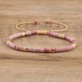 Detailed close-up of pink emperor stone beads with gold spacers on wood background - No.20 Wood Grain Stone