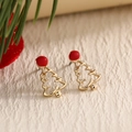 Festive gold Christmas tree stud earrings with red enamel top on textured background - Hollow Christmas Tree (EAR0042)