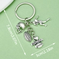 Silver American football keychain with helmet and player charms on a green background - Rugby Athlete Helmet