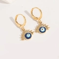 Detailed close-up of golden evil eye earrings with vibrant blue enamel finish - Royal Blue Evil Eye