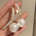 Detailopname van gouden oorringen met grote parels en rechthoekige zirkonia inlays - Zirconia Parel Hoop (ER21Y0034)