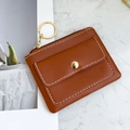 Brown PU leather key pouch with gold buckle and stitching detail in flat lay style - Coffee