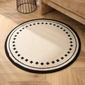 Round thick beige woven rug with black geometric patterns on a wooden floor - Mellag White