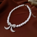 Elegant pearl necklace with a sparkling crystal bow pendant on dark silk background - Silver White Zirconia Bow Pearl Necklace