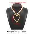 Dettaglio della collana con grandi perle bianche e ciondolo a cuore vuoto sovradimensionato - Cuore / Oro