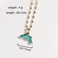 Detalle de collar de delfín dorado con cadena de 40+5cm y colgante de tamaño 10x17mm - Delfín Azul