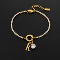 Elegant gold stainless steel tennis bracelet with a sparkling rhinestone letter K charm - Letter K