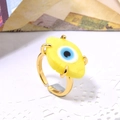 Close-up of golden adjustable ring featuring a vibrant yellow evil eye glass inlay - Adjustable Open / Yellow
