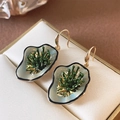 Macro detail of enamel leaf earrings with gold stamens in a beige jewelry box - Silver Earring Post-Green