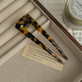 Detalle de horquilla de acetato con patrón de carey y logotipo de Francia hecho a mano - Estampado de Leopardo Oscuro