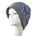 Blue denim knit slouchy beanie with vintage butterfly embroidery on a mannequin head - Gray