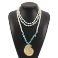 Detail of bohemian layered necklace with white pearls, turquoise and gold conch pendant - Conch Pendant / Blue + Gold