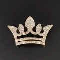 Macro shot of a golden alloy crown brooch with white sparkling rhinestones on black background - Full Rhinestone Gold Crown