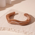 Detail of acrylic wavy open bangle with brown marble texture on a stone pedestal - Dark Coffee