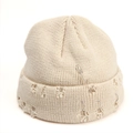 Detail of beige knit beanie with silver safety pin, metal rings and distressed holes - Beige