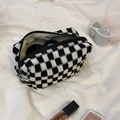 Top view of a thick knit checkered cosmetic bag filled with makeup accessories - Black and White Plaid