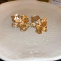 Goldene blumenförmige Metallohrringe mit Struktur auf einer Keramikplatte - Stil 4 Gold Metallblume - Silver Earring Post