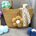 Detail view of a soft plush flower keychain hanging on a stylish straw tote bag - 1 Piece / Khaki