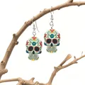 Macro detail of colorful Day of the Dead calavera skull earrings on a wooden branch - White with Red Eye Sockets and Floral