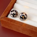 Macro view of vintage round leopard print earrings with silver beaded edges on brown suede - White Round Small
