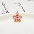 Macro shot of pink zircon five-petal flower pendant with gold plating and dual connectors - Pink