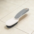 Detail of shoe brush with ergonomic gray handle, hanging hole and dense black bristles - Gray