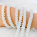 Macro detail of creamy white translucent abacus beads bracelets on a plush background - 5*8mm Approx 75pcs per strand / White Jade