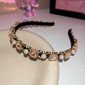 Detail of luxury headband with white pearls and champagne gems on a ceramic plate - Champagne